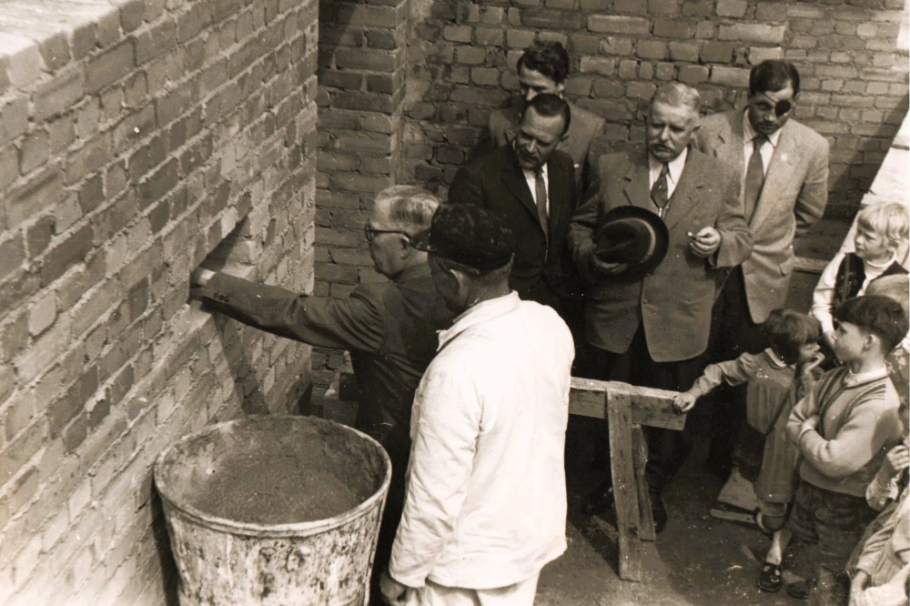 Das ging den Maurern aber flott von den Kellen! Kaum ragen die Fundamente aus der Erde gibt es die nächste Feier - der Bürgermeister mauert am 14. Mai 1956 die Erinnerungsurkunde ein. Marienfeldschule